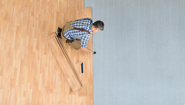 Worker Assembling New Laminate Floor | Wellston Decorating Center, Inc.